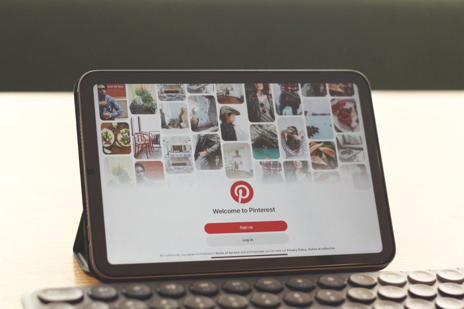 Person using a tablet to browse Pinterest for business ideas and visual search.