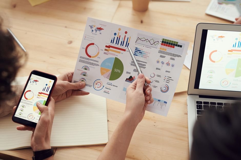 Marketing professionals discussing content strategy, with AI insights visible on a screen, utilizing modern tools.