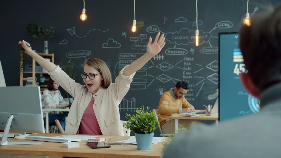 Joyful woman celebrating small business growth through technology, emphasizing SMB automation success.