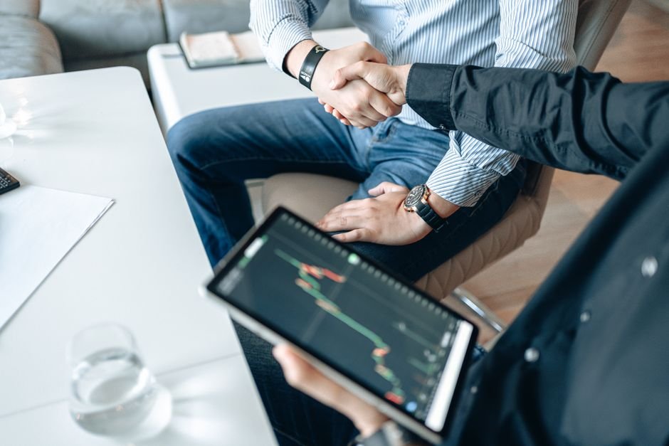 Business professionals shaking hands after a successful custom software development transaction