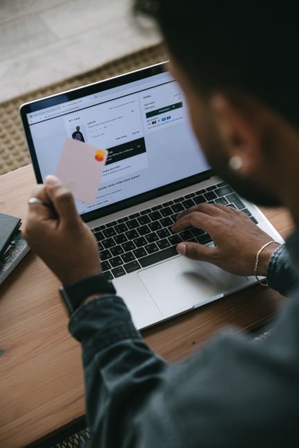 Customer using a credit card and laptop for online shopping, focusing on secure payments.